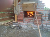 Feuerprobe mit nasser Holzbohle vor der oberen Ofentür